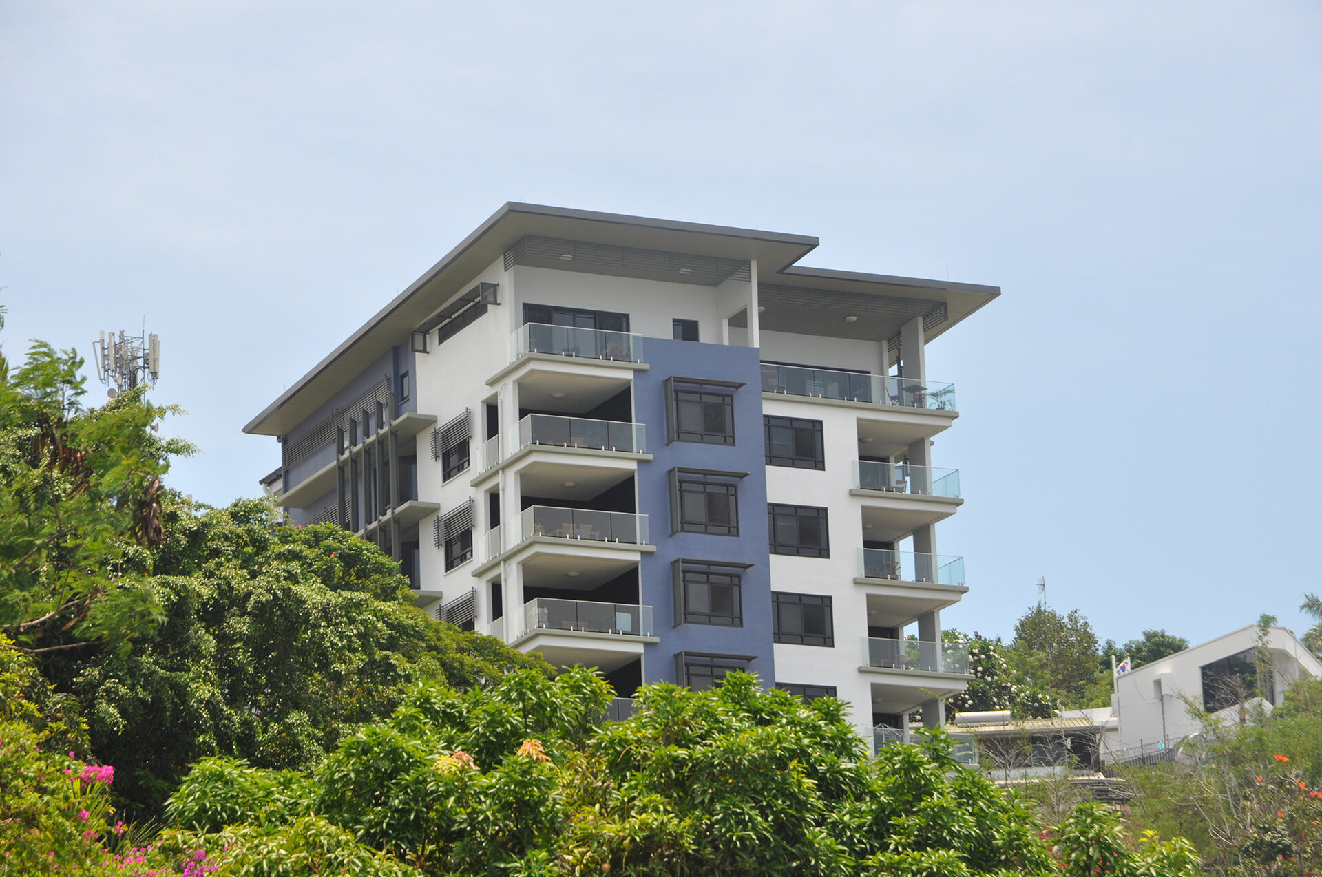 Touguba Hill Apartment building set behind tall trees.