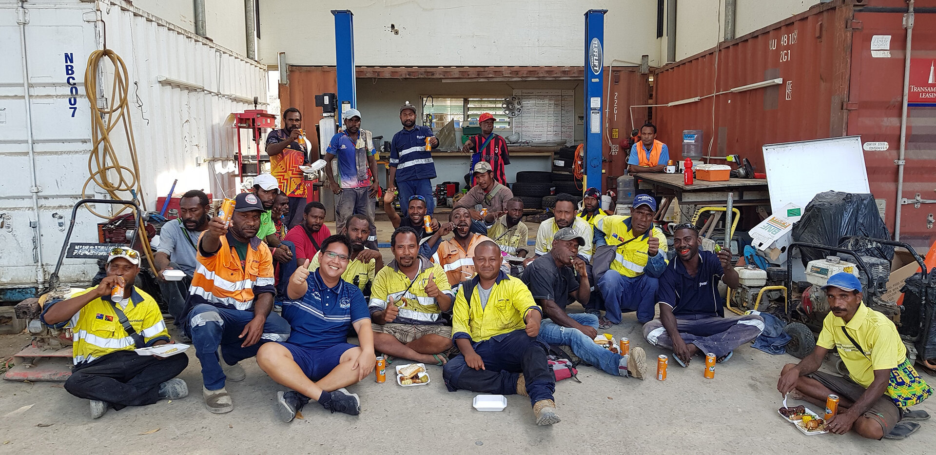The Papua New Guinea Northbuild team sits together in a workshop for a group photo.